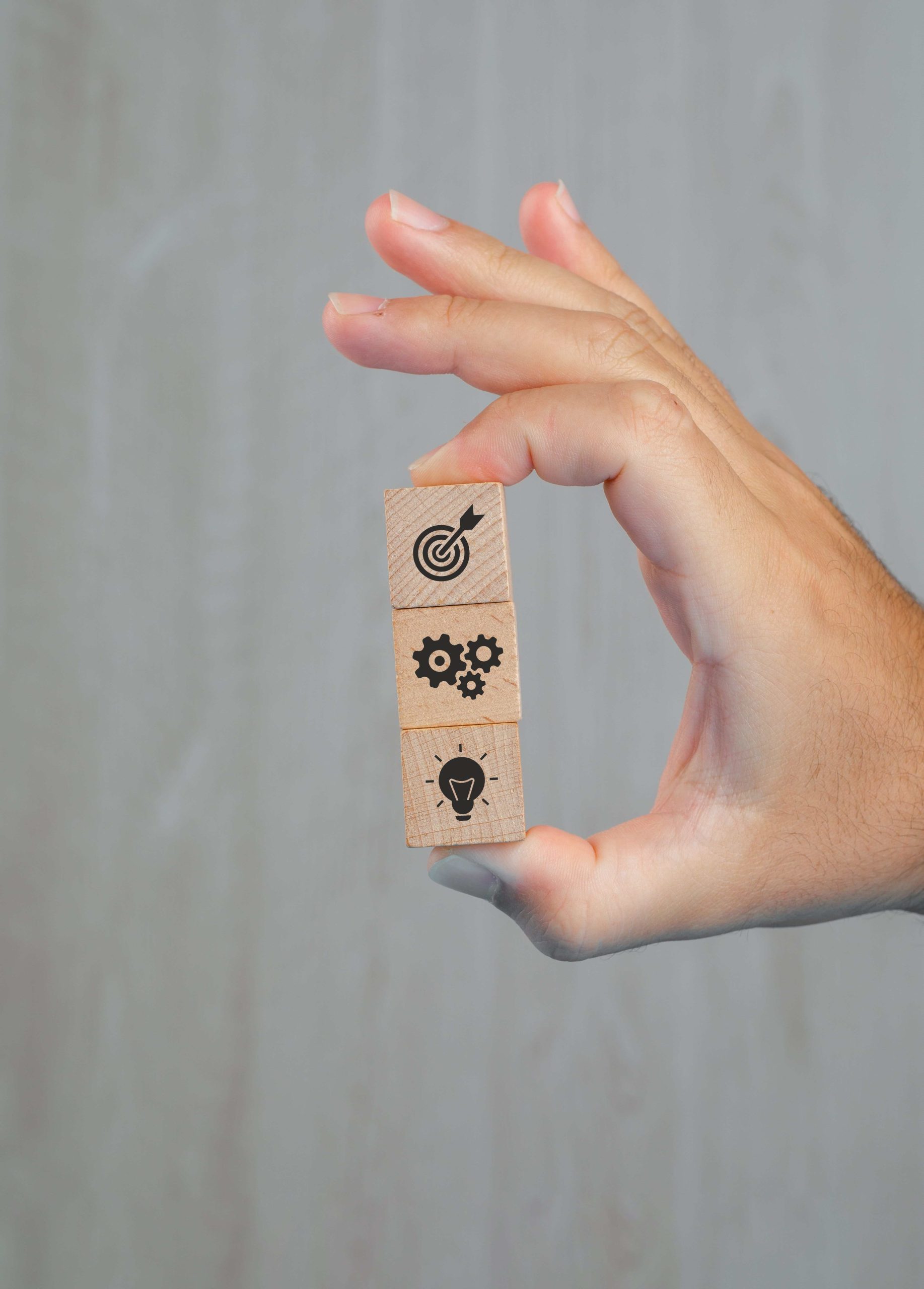concepto-de-negocio-en-vista-lateral-de-la-mesa-gris-mano-sosteniendo-cubos-de-madera-con-iconos